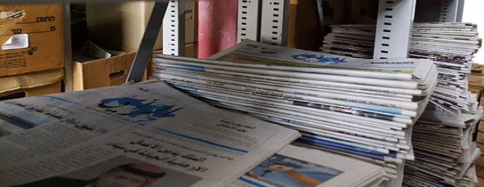 Stack of Arabic newspapers on a shelf